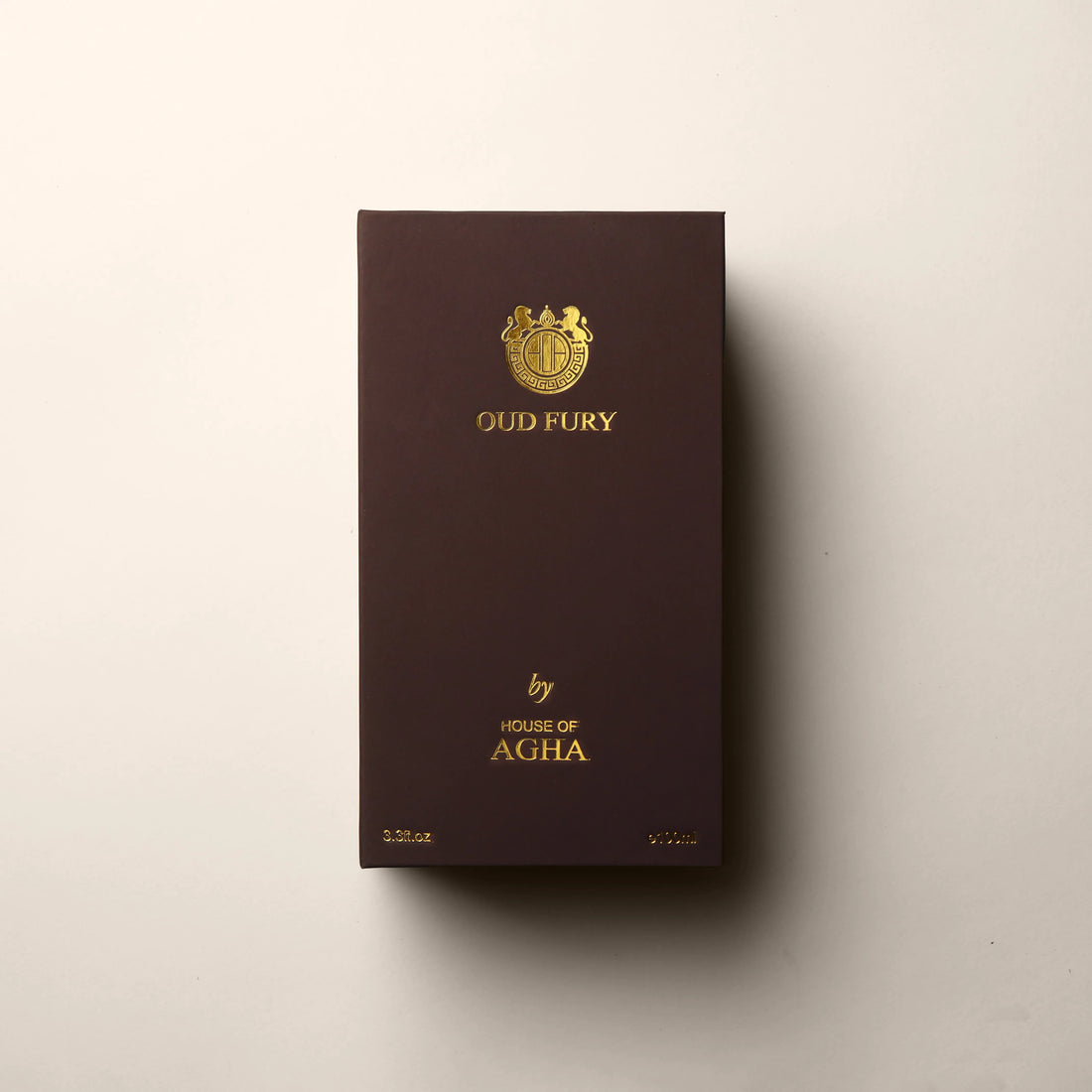 A wooden-textured box for Tobacco Enigma Eau de Parfum by House of Agha, displaying the brand logo and name in gold, with a capacity of 3.3 fl oz (100ml), set against a plain background.